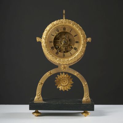 a clock that is sitting on a stand on a table