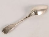 a spoon that is sitting on a white surface