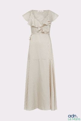 La robe est blanche et est parsemée de pois.