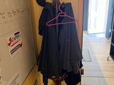 a coat rack with clothes hanging on it in a hallway