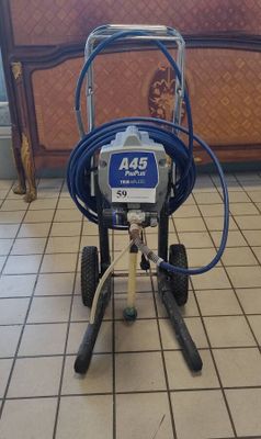 a picture of a small airless paint sprayer on a tiled floor