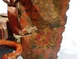 un objet métallique rouillé posé sur une table, à côté d'autres objets