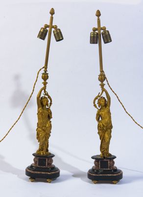 paire de lampes anciennes en laiton sur des socles en marbre, représentant une femme tenant une cloche