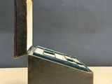 a metal box with a book inside of it on a table