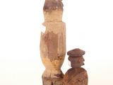 an image of a wooden statue of a man with a hat and a bird