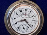 a silver pocket watch with roman numerals on it