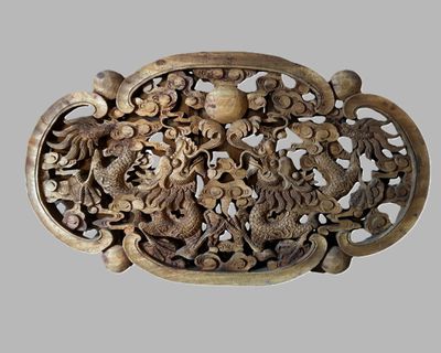 une sculpture en bois représentant un dragon et d'autres animaux, exposée