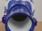 a blue and white vase sitting on a wooden table