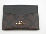 un porte-cartes de type « coach » à motifs marron et noir