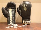 une paire de gants de boxe noirs posée sur une table en bois