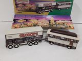 three toy trucks are sitting next to each other in front of a box