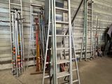 several ladders are lined up in a warehouse with a lot of tools