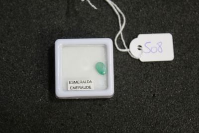 a small white box with a green bead on it