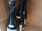 three bottles of wine sitting on a shelf with a spider web