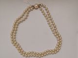 gros plan d'un collier de perles sur une surface blanche