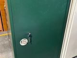une porte verte munie d'une serrure dans un entrepôt