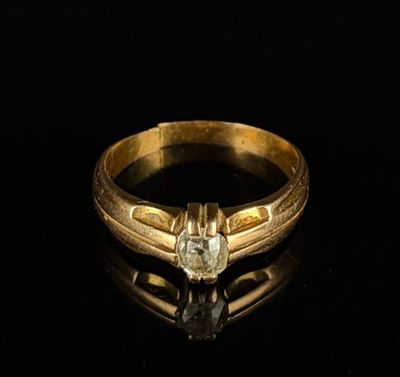 un gros plan d'une bague en or sertie d'un diamant sur un fond noir