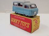 un petit bus jouet bleu posé sur une boîte