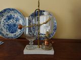 a blue and white plate on a table with a wine glass on it