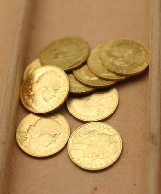 beaucoup de pièces d'or dans une boîte posée sur la table
