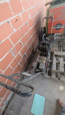 un homme qui se tient debout à côté d'un mur de briques