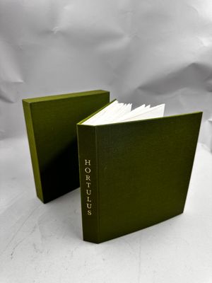 deux livres verts posés l'un à côté de l'autre sur une surface blanche