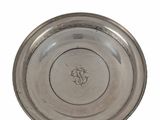 an old silver plate with a monogram on it on a white background