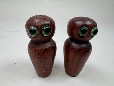 paire de figurines en bois représentant des chouettes aux yeux verts sur fond blanc