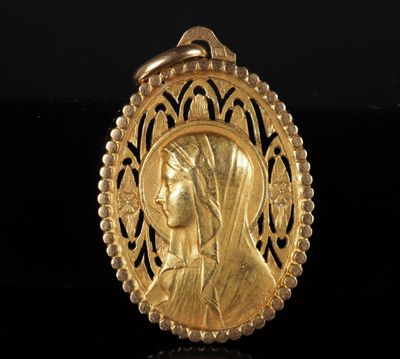 une image représentant un pendentif en or orné du visage d'une femme