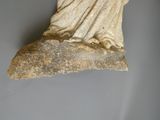 une statue de femme assise au sommet d'un rocher