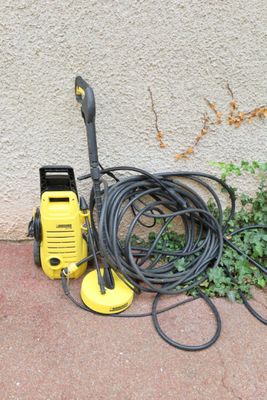 a yellow pressurer sitting on the ground next to a green plant