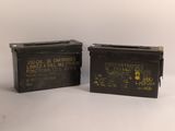 deux vieilles boîtes de munitions militaires posées côte à côte sur une surface blanche