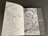 an open book with a drawing of a woman sitting on a table