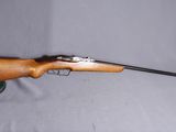 Le fusil est posé sur la table, avec un chapeau dessus.
