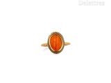 an image of a gold ring with an orange stone in the center