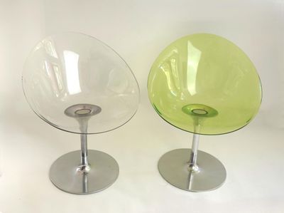 two chairs sitting next to each other on a white surface