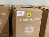 trois cartons de vin posés par terre dans une pièce
