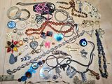 many different types of necklaces and bracelets laid out on the floor