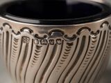 a close up of a silver cup on a table