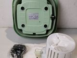 a green box with a white and black electronic device on it