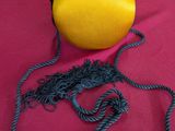 yellow purse on a red table cloth with a rope around it