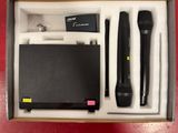 une boîte ouverte contenant deux microphones et un bloc-notes