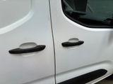 a white van with black handles parked on the side of the road