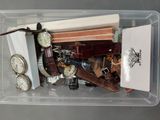 un bac en plastique rempli de montres diverses et d'autres objets