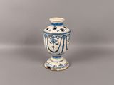 un vase bleu et blanc posé sur une surface grise