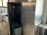 une photo d'une cuisine professionnelle avec un réfrigérateur et une poubelle
