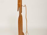 a wooden sculpture of a man holding a bottle of wine