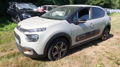 une petite voiture blanche garée sur l'herbe, dans le champ