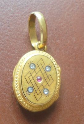 un cadenas doré avec une pierre rose à l'intérieur