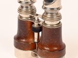 une paire de jumelles anciennes en bois et en métal sur fond blanc